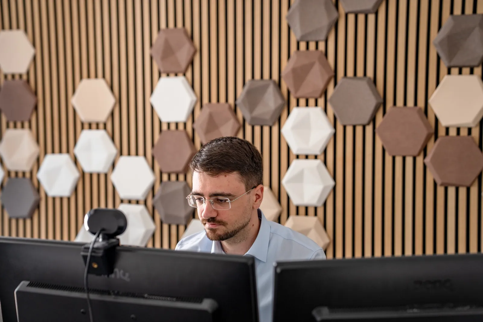 Datenanalyst arbeitet konzentriert an zwei Monitoren an der Auswertung einer Marktforschungsstudie